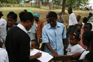 A community health worker registering patients at a rural health fair